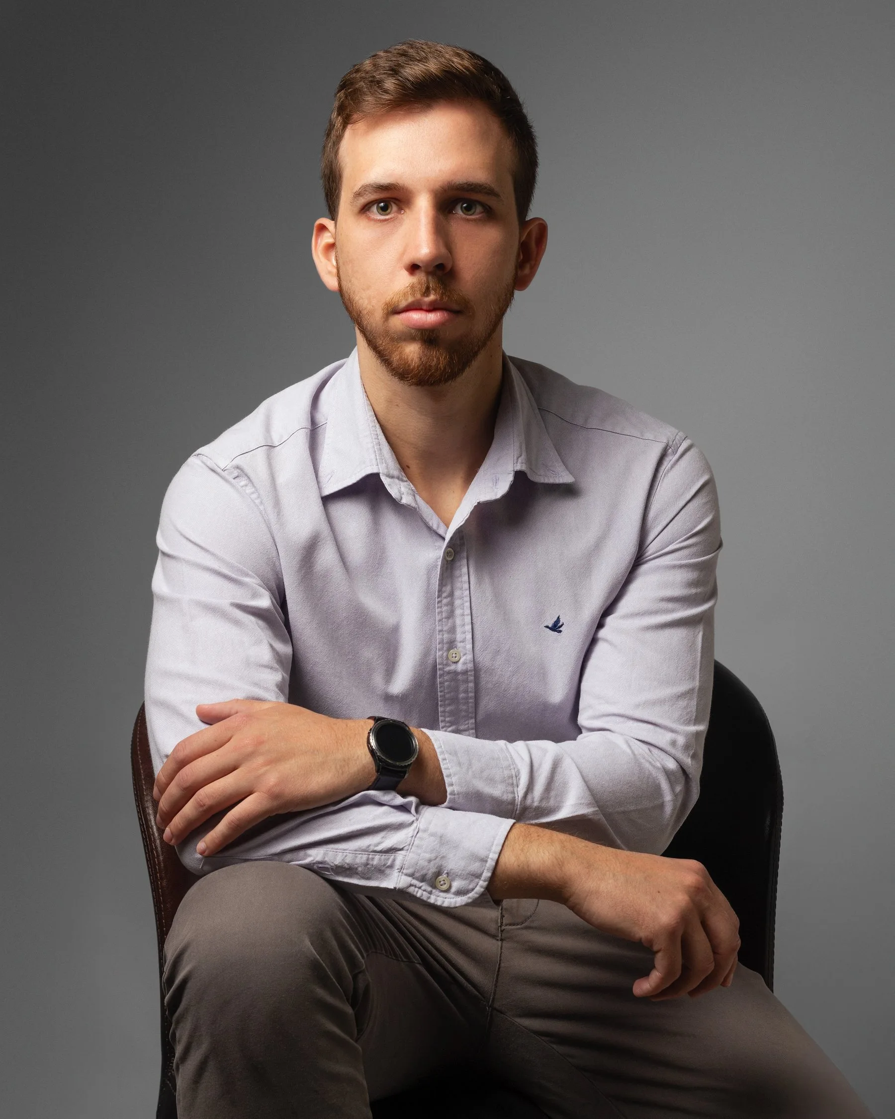 Dr. João Lucas Rosa sentado, camisa clara, olhando para a câmera
